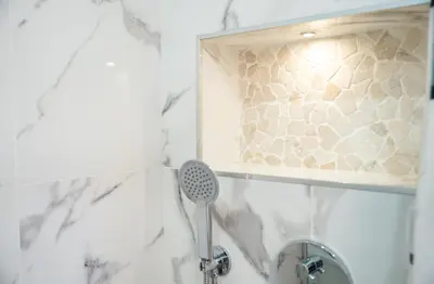 a shower with a shower head in a bathroom at Gyula Old Town Apartment in Albufeira