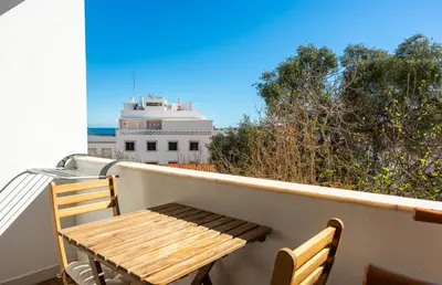 a wooden table and chairs on a balcony at Gyula Old Town Apartment in Albufeira