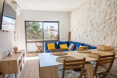 a living room with a table and chairs and a blue couch at Gyula Old Town Apartment in Albufeira