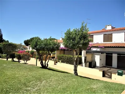 a house with trees and a grass yard at V2 Vilar Jardim Piscina wifi in Quarteira