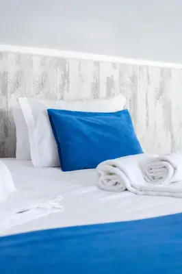 a blue pillow and white pillows on a bed at #197 Casa Gili by Home Holidays in Albufeira