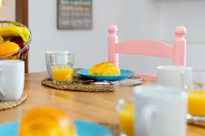 a table with a bowl of fruit and a glass of orange juice at #197 Casa Gili by Home Holidays in Albufeira