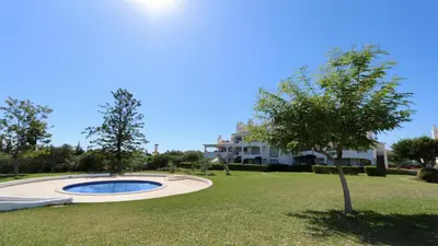 a tree in a yard with a building in the background at Green Valley 05, Cleverdetails, Sleeps 6 adults and 2 children, 4 salted water pools in Vilamoura