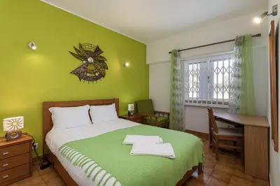 a green bedroom with a bed and a desk at The Albufeira Concierge - Albufeira City Center in Albufeira