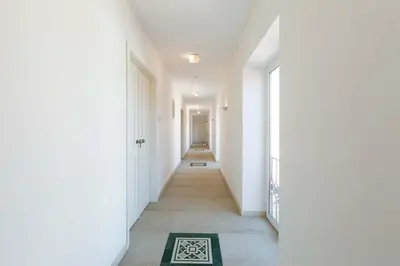 a hallway with white walls and a rug on the floor at Villa Ataboeira in Guia