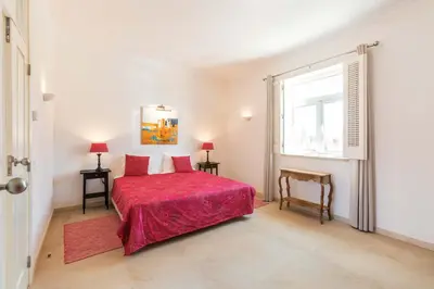a bedroom with a red bed and a window at Villa Ataboeira in Guia