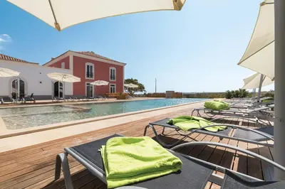 a group of chairs sitting next to a swimming pool at Villa Ataboeira in Guia