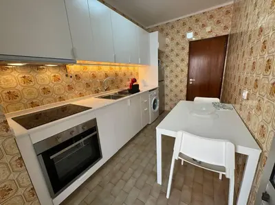 a kitchen with a white table and a stove and a counter at XperienceHouse Algarve in Quarteira