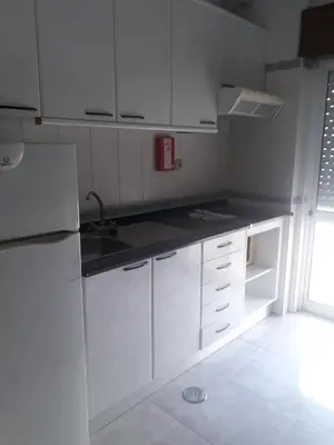 a white kitchen with white cabinets and a sink at STUDIO COMPLETO PARA 2 PESSOAS in Albufeira