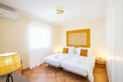 a bedroom with two beds and a window at Villa alhabu in Albufeira