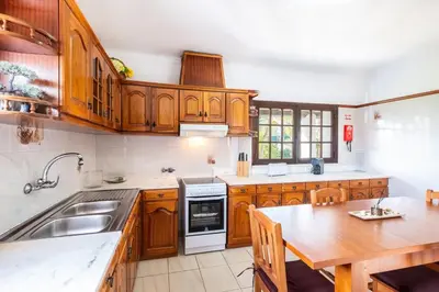 a kitchen with wooden cabinets and a wooden table at Villa Guerreiro in Albufeira