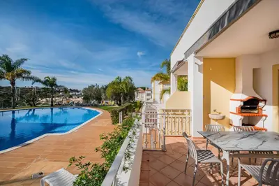 a patio with a table and chairs next to a swimming pool at Villa Adriana in Albufeira
