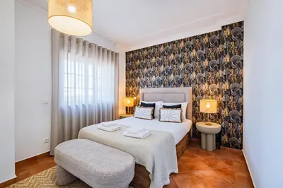 a bedroom with a bed and a table and a chair at Villa Adriana in Albufeira