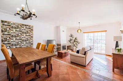 a dining room and living room with a table and chairs at Villa Adriana in Albufeira