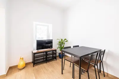 a dining room with a black table and chairs at SERAFIM BEACH APARTMENT - Heart of the Old Town in Albufeira