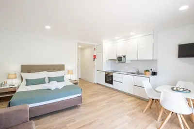 a large bedroom with a bed and a kitchen at Studio Guerreiro in Albufeira
