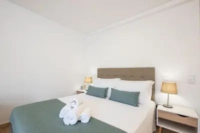 a bedroom with a white bed with towels on it at Studio Guerreiro in Albufeira