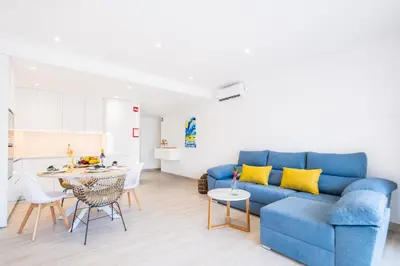 a living room with a blue couch and a table at Guerreiros Lovely Stay in Albufeira