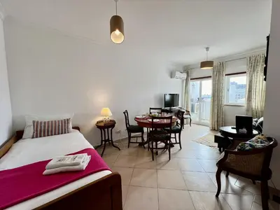 a bedroom with a bed and a table and chairs at Albufeira Vintage Apartment 1 With Pool by Homing in Albufeira