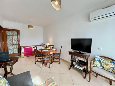 a living room with a television and a table with chairs at Albufeira Vintage Apartment 1 With Pool by Homing in Albufeira