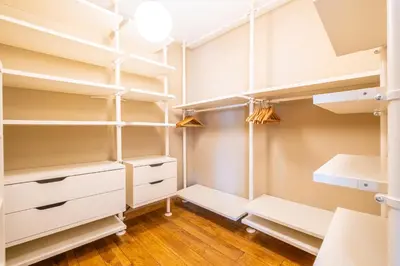 a walk in closet with white shelves and lights at Casa Picota in Boliqueime