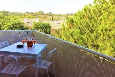 a table on a balcony with two glasses of wine at Charming 3 bed apartment @ Al-Sakia Village in Quarteira