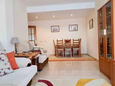 a living room with a couch and a table and chairs at Charming 3 bed apartment @ Al-Sakia Village in Quarteira