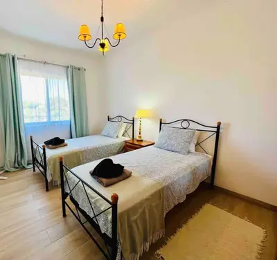 a bedroom with two beds and a chandelier at Charming 5 bed Private Villa - Quarteira in Quarteira
