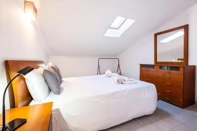 a bedroom with a white bed with a dresser and a mirror at Apartment Arrifes in Albufeira