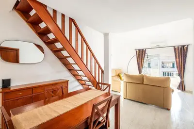 a living room with a staircase and a couch at Apartment Arrifes in Albufeira