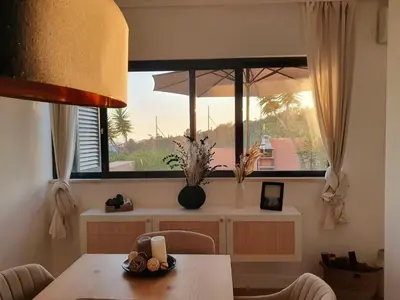 a dining room with a table and a large window at Three Bedroom Sea View Townhouse Villa in Albufeira
