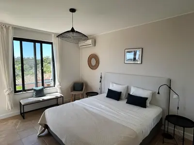 a bedroom with a white bed and a large window at Three Bedroom Sea View Townhouse Villa in Albufeira