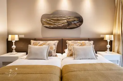 two beds sitting next to each other in a bedroom at Pine Cliffs Suites in Albufeira
