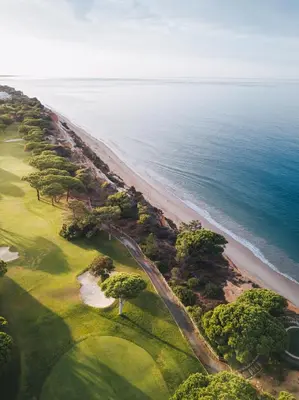 an aerial view of a golf course and the ocean at Pine Cliffs Suites in Albufeira