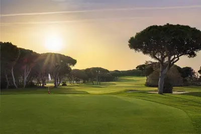 a golf course with a tree on a green at Pine Cliffs Suites in Albufeira