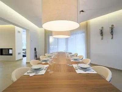 a long dining room with a long table and chairs at Contemporary Vilamoura Villa Stunning Open Plan Design Villa Azure Elegance in Quarteira