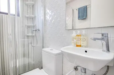 a bathroom with a toilet and a sink and a shower at Lovely 3BD 150m Beach Ocean View AC Wi-Fi Balcony in Albufeira