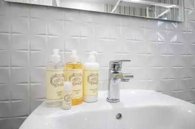 three bottles ofodorizers sitting on a bathroom sink at Lovely 3BD 150m Beach Ocean View AC Wi-Fi Balcony in Albufeira