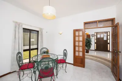 a dining room with a glass table and chairs at Villa Cavaco in Vilamoura