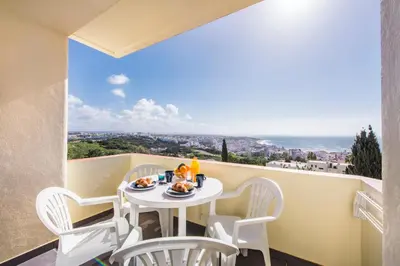 a table and chairs on a balcony with a view of the ocean at Lagoon Bleue in Albufeira