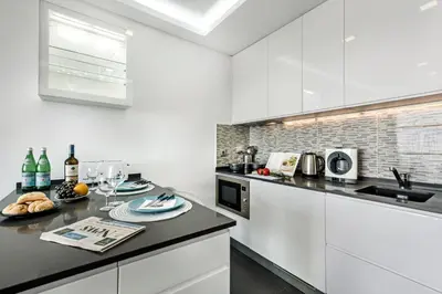 a kitchen with white cabinets and a black counter top at Lagoon Bleue in Albufeira