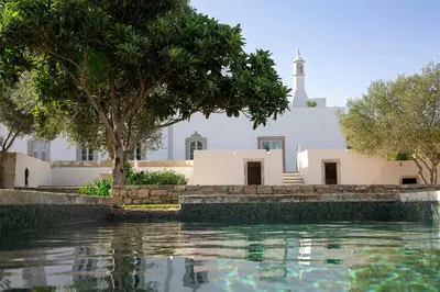 a church and a swimming pool in front of a building at Solar do Bisavô in Bordeira