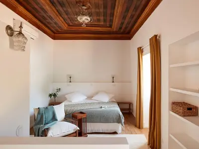 a bedroom with a bed and a wooden ceiling at Solar do Bisavô in Bordeira