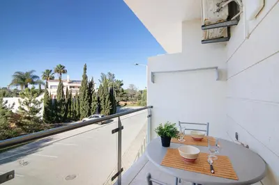 a table on a balcony with a view of a street at Algarve Paraíso - Monte da Balaia in Olhos de Água