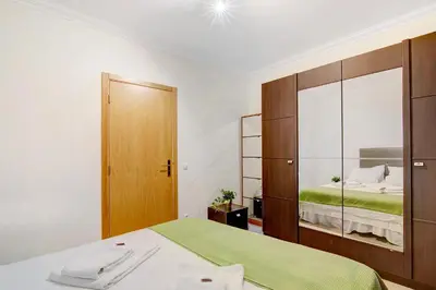 a bedroom with a bed with a green and white blanket at Algarve Paraíso - Monte da Balaia in Olhos de Água