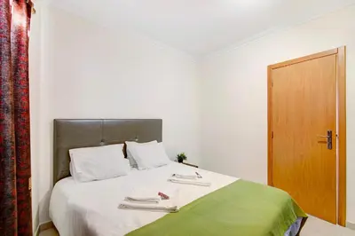 a bedroom with a large bed with a wooden door at Algarve Paraíso - Monte da Balaia in Olhos de Água