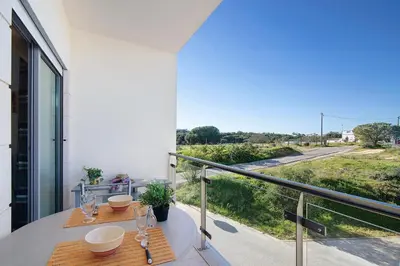 a balcony with two tables and a view of a street at Algarve Paraíso - Monte da Balaia in Olhos de Água