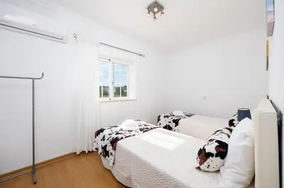 a white kitchen with white cabinets and a dishwasher at Villa Marlene in Guia
