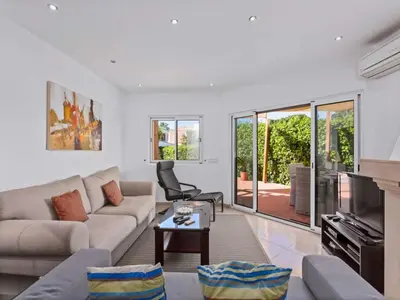 a patio with a table and chairs and an umbrella at Charming Vilamoura Villa Short Walk To Marina Villa O Clube 3 Bedrooms in Quarteira