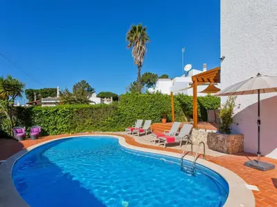 a swimming pool with chairs and an umbrella at Charming Vilamoura Villa Short Walk To Marina Villa O Clube 3 Bedrooms in Quarteira